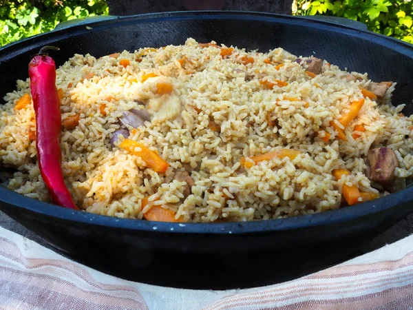 Kırmızı biberli bir kazanda pilav. et ve pirinç.