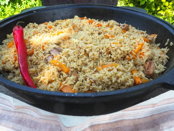 Kırmızı biberli bir kazanda pilav. et ve pirinç.