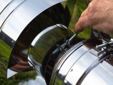 Saptırıcıyı ısıtma borusuna yerleştiriyorum. Sandviç piposu. İnşaat. Eller çerçevede.