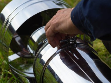 Saptırıcıyı ısıtma borusuna yerleştiriyorum. Sandviç piposu. İnşaat. Eller çerçevede.