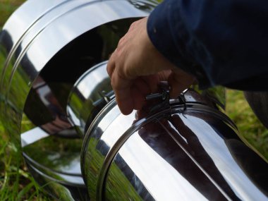 Saptırıcıyı ısıtma borusuna yerleştiriyorum. Sandviç piposu. İnşaat. Eller çerçevede.