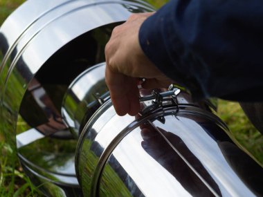 Saptırıcıyı ısıtma borusuna yerleştiriyorum. Sandviç piposu. İnşaat. Eller çerçevede.