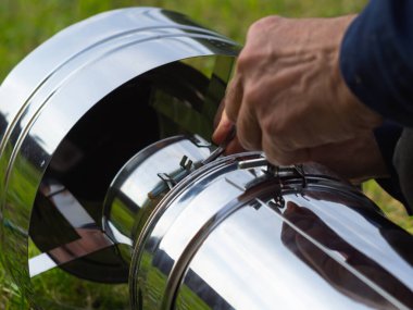 Saptırıcıyı ısıtma borusuna yerleştiriyorum. Sandviç piposu. İnşaat. Eller çerçevede.