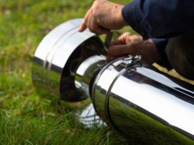 Saptırıcıyı ısıtma borusuna yerleştiriyorum. Sandviç piposu. İnşaat. Eller çerçevede.