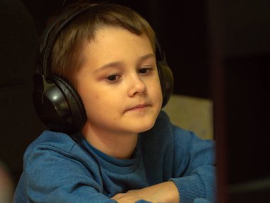 Bilgisayarın başındaki kulaklıklı çocuk. Online çalışma. Dersleri dinliyor. eğitim.