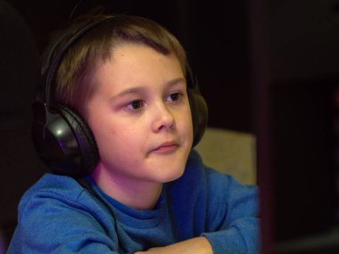 Bilgisayarın başındaki kulaklıklı çocuk. Online çalışma. Dersleri dinliyor. eğitim.