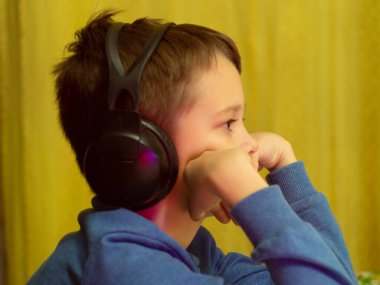 Bilgisayarın başındaki kulaklıklı çocuk. Online çalışma. Dersleri dinliyor. eğitim.