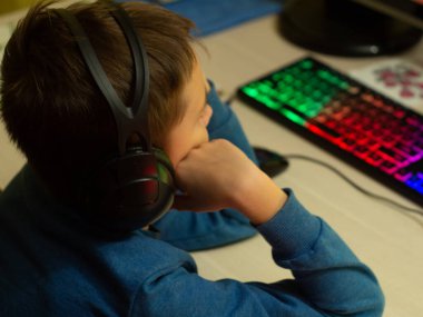 Bilgisayarın başındaki kulaklıklı çocuk. Online çalışma. Dersleri dinliyor. eğitim.