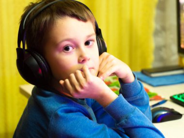 Bilgisayarın başındaki kulaklıklı çocuk. Online çalışma. Dersleri dinliyor. eğitim.