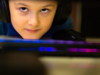 Bilgisayarın başındaki kulaklıklı çocuk. Online çalışma. Dersleri dinliyor. eğitim.