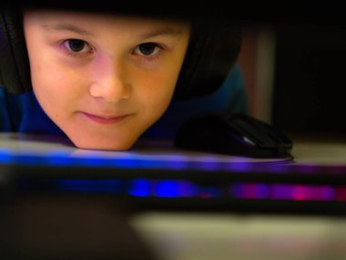 Bilgisayarın başındaki kulaklıklı çocuk. Online çalışma. Dersleri dinliyor. eğitim.