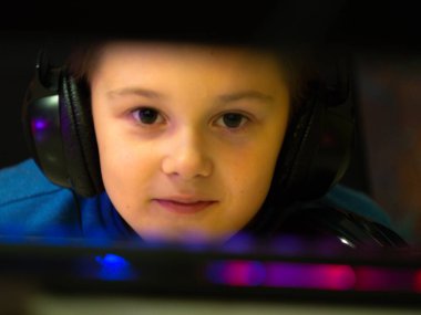 Bilgisayarın başındaki kulaklıklı çocuk. Online çalışma. Dersleri dinliyor. eğitim.