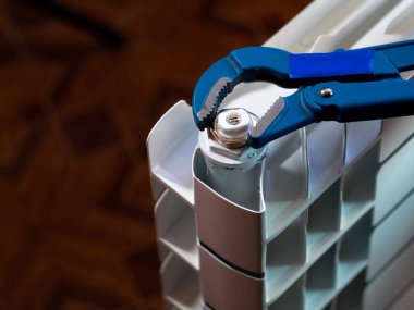 Fındıkları radyatördeki ayarlanabilir anahtarla çevir. Eve radyatör yerleştiriliyor.