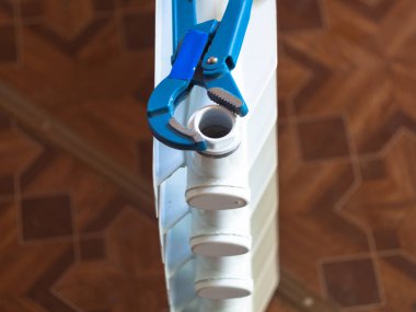 Fındıkları radyatördeki ayarlanabilir anahtarla çevir. Eve radyatör yerleştiriliyor.