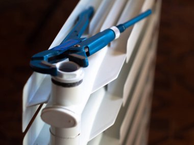 Fındıkları radyatördeki ayarlanabilir anahtarla çevir. Eve radyatör yerleştiriliyor.