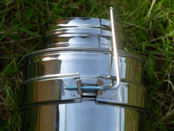 Yerdeki fırınlar için boru hatlarının montajı. Yeşil çimlerin üzerinde pipo sandviç.