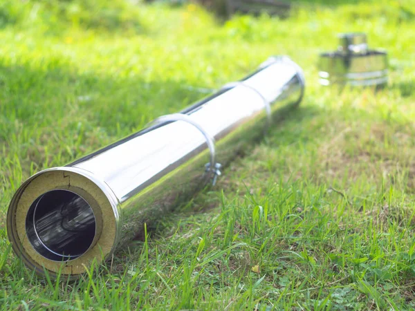 Yerdeki fırınlar için boru hatlarının montajı. Yeşil çimlerin üzerinde pipo sandviç.