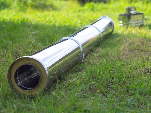 Yerdeki fırınlar için boru hatlarının montajı. Yeşil çimlerin üzerinde pipo sandviç.