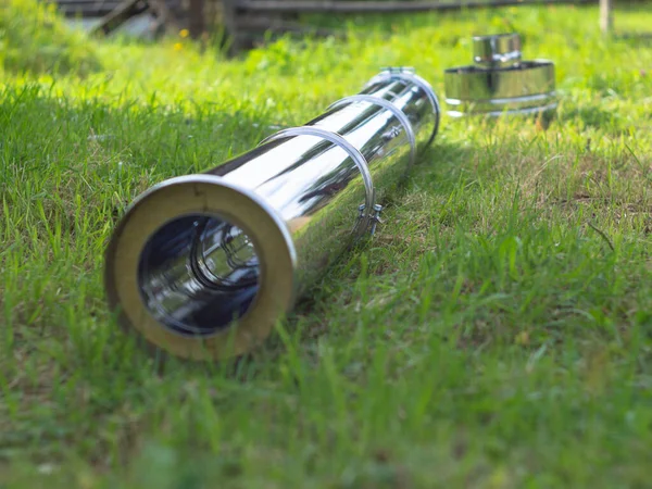 Yerdeki fırınlar için boru hatlarının montajı. Yeşil çimlerin üzerinde pipo sandviç.