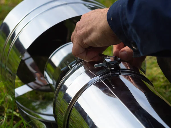 Saptırıcıyı ısıtma borusuna yerleştiriyorum. Sandviç piposu. İnşaat. Eller çerçevede.