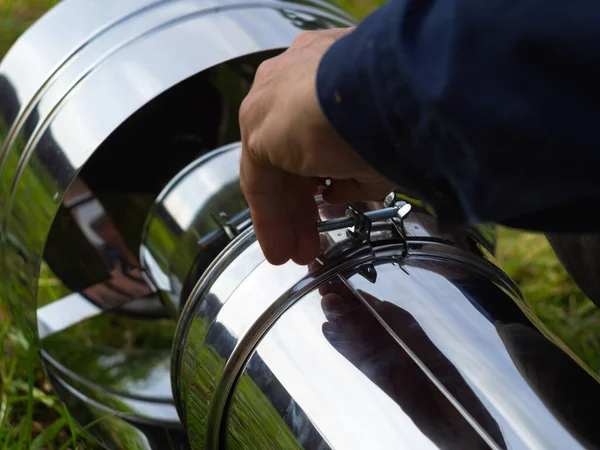 Saptırıcıyı ısıtma borusuna yerleştiriyorum. Sandviç piposu. İnşaat. Eller çerçevede.