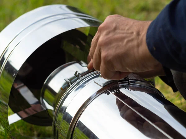 Saptırıcıyı ısıtma borusuna yerleştiriyorum. Sandviç piposu. İnşaat. Eller çerçevede.