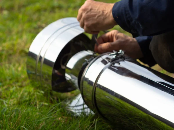 Saptırıcıyı ısıtma borusuna yerleştiriyorum. Sandviç piposu. İnşaat. Eller çerçevede.