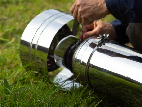 Saptırıcıyı ısıtma borusuna yerleştiriyorum. Sandviç piposu. İnşaat. Eller çerçevede.