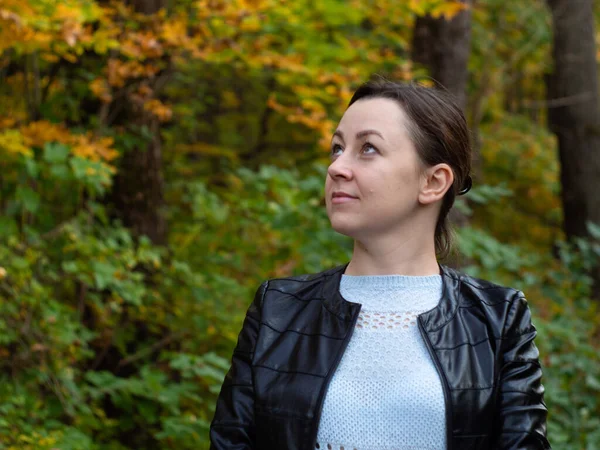 Parkta yürüyüş yapan bir kız. Sarı yapraklar. Sonbahar. Temiz havada sağlık yürüyor..