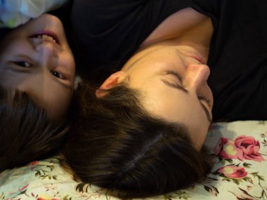 Gülümseyen çocuk annesiyle yatakta yatıyor. Komik çocuğun bir annesi olacak..