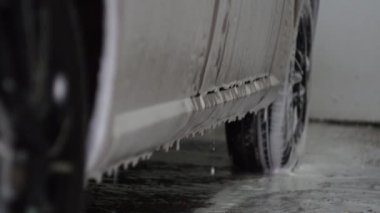 Araba yıkamadaki arabadan köpük damlıyor, oto yıkamacıda oto yıkama servisi var.