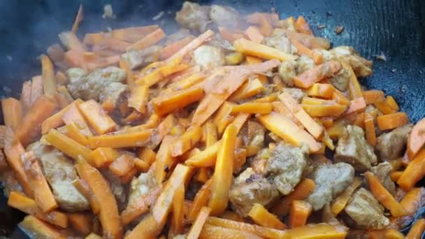 Kazan 'da yemek pişirmek. Havuçlu ve soğanlı kızarmış et. pilav hazırlığı — Stok video