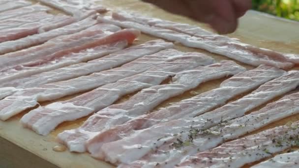 Slănină proaspătă presărată cu condimente. bacon de porc pe o placă de lemn — Videoclip de stoc