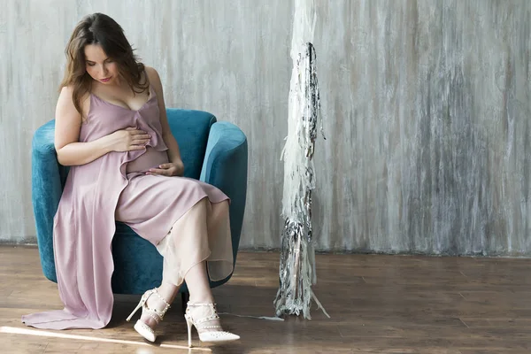Młoda Kobieta Ciąży Fioletowa Sukienka Siedząc Krześle Ciemnoszare Tło — Zdjęcie stockowe