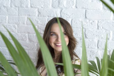 Bir genç kızın yüzünü kapatmak - beyaz duvara.