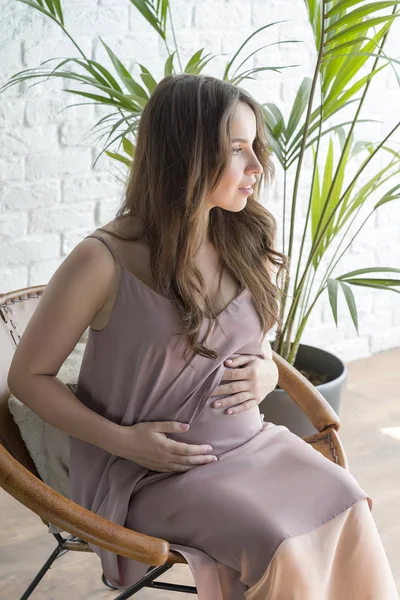 Chica Embarazada Sentada Una Silla Sobre Fondo Ladrillo Blanco — Foto de Stock