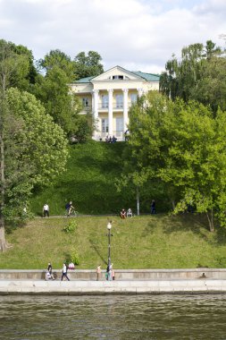 Bir güneşli yaz günü Moskova Nehri boyunca set boyunca insanlar yürümek.