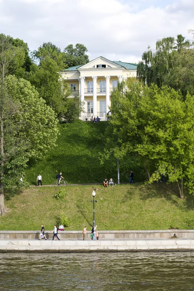 Bir güneşli yaz günü Moskova Nehri boyunca set boyunca insanlar yürümek.