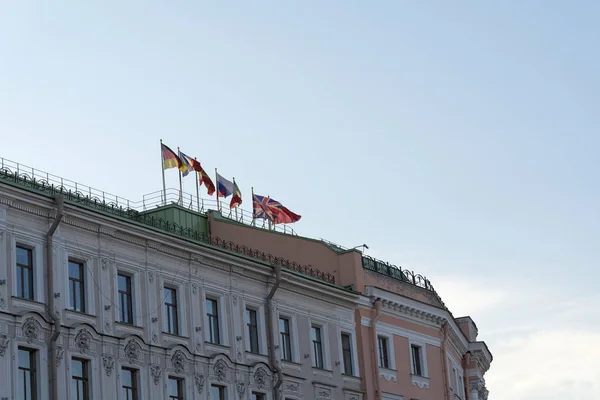 Different flags over the building in St. Petersburg against the sky.