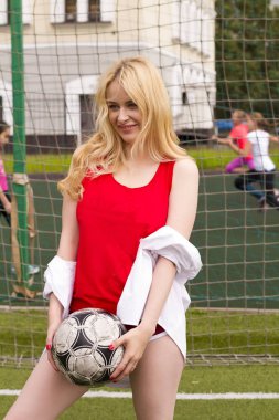 Sarışın bir top futbol sahasına kapısında ile kırmızı formunda. Futbol gol fotoğraf çekimi.