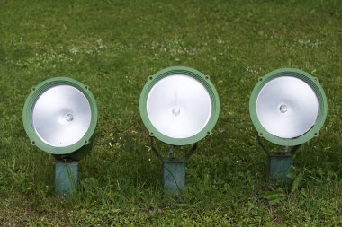 Parkta yeşil çim üzerinde üç küçük spot.