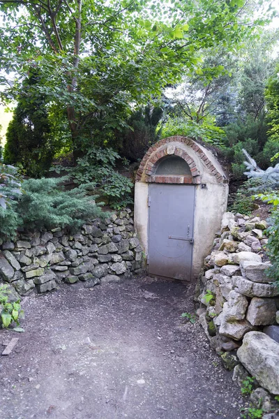 An old bomb shelter in the forest with a forced closed door on a summer day.