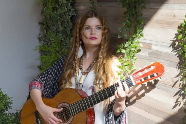 Kırmızı kıvırcık saçlı güzel bir kız anlamına gelir ve yedi telli gitar onun elinde tutar. Yeşil yaprakları ile stüdyo.