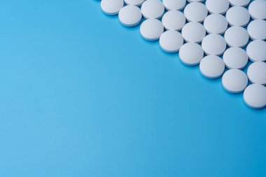 Sağ üst köşesinde mavi bir arka plan üzerinde beyaz tıp hapları. İlaç Laboratuvar.