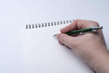 Bir defter ve bir kalem beyaz bir arka planda tutan bir adam elinde. Bellek için Not Defteri'ne yazma.