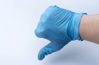 Bir elinde mavi eldiven aşağı bir parmağını gösterir. Doktor puan düştü.