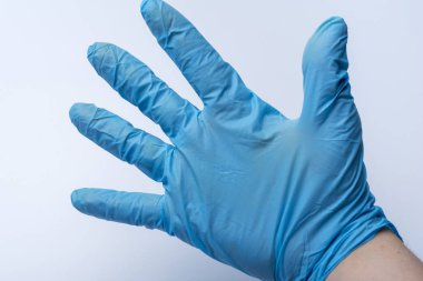Eldiven elinde beş parmak beyaz arka plan üzerinde gösterir. Doktor el bir mavi lateks eldiven.