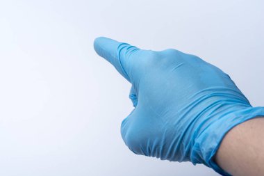 İşaret parmağı ile eldivenli elini puan. Doktor el bir mavi lateks eldiven.