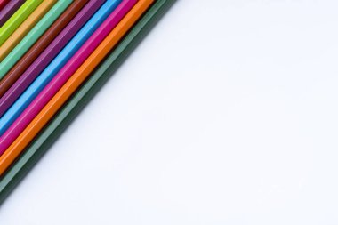 Beyaz arka plan yakın sol üst köşede üzerinde renkli kalemler. Renkli kalemler ile çizim.