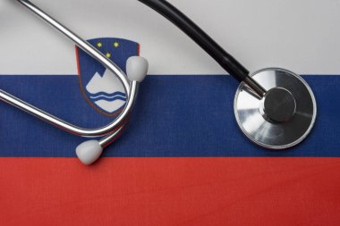 Stetoskop ve Slovenya bayrağı. Tıp kavramı. Stetoskop bir arka plan olarak bayrağı.